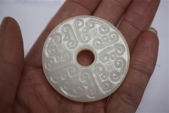 A Chinese white jade bi disc, diameter 4.6cm, wood stand